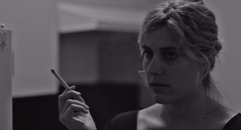 Movie still from “Frances Ha” (2012), directed by Noah Baumbach – A black and white photo of a woman holding a cigarette; Close Up shot, Over the shoulder angle