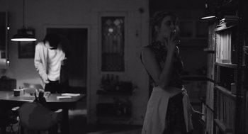 Movie still from “Frances Ha” (2012), directed by Noah Baumbach – A woman standing in a kitchen holding a spoon; Medium shot, Over the shoulder angle