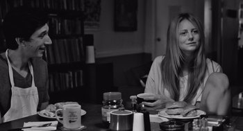 Movie still from “Frances Ha” (2012), directed by Noah Baumbach – A woman sitting at a table with a cup of coffee; Medium shot, Over the shoulder angle