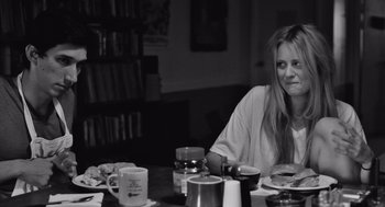 Movie still from “Frances Ha” (2012), directed by Noah Baumbach – A woman sitting at a table with a plate of food; Medium shot, Over the shoulder angle