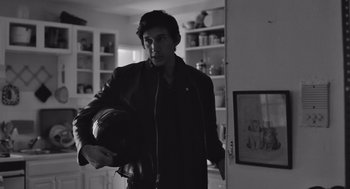 Movie still from “Frances Ha” (2012), directed by Noah Baumbach – A man holding a helmet in a room; Medium shot, Over the shoulder angle
