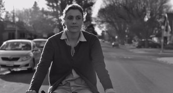 Movie still from “Frances Ha” (2012), directed by Noah Baumbach – A woman riding a bicycle down a street; Close Up shot, Low angle