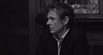 Movie still from “Frances Ha” (2012), directed by Noah Baumbach – Black and white photograph of a man in a suit looking to his left; Close Up shot, Low angle