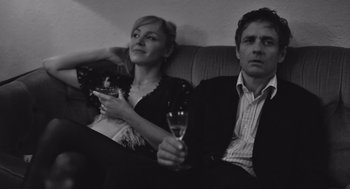 Movie still from “Frances Ha” (2012), directed by Noah Baumbach – A man and a woman sitting next to each other on a couch; Medium shot, Low angle