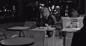 Movie still from “Frances Ha” (2012), directed by Noah Baumbach – A woman sitting at a table with a cup of coffee; Medium shot, Over the shoulder angle
