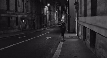 Movie still from “Frances Ha” (2012), directed by Noah Baumbach – A person walking down a street at night; Wide shot, Low angle