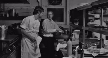 Movie still from “Frances Ha” (2012), directed by Noah Baumbach – Two men standing in a kitchen preparing a meal; Medium shot, Low angle