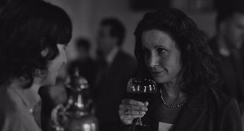 Movie still from “Frances Ha” (2012), directed by Noah Baumbach – A black and white photo of a woman holding a glass of wine; Close Up shot, Over the shoulder angle