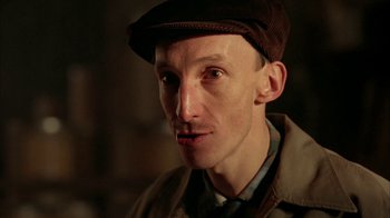 Movie still from “Naked Lunch” (1991), directed by David Cronenberg – A person wearing a hat; Close Up shot, Low angle