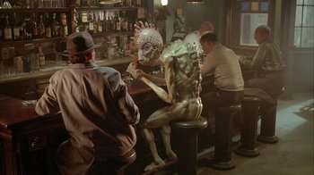 Movie still from “Naked Lunch” (1991), directed by David Cronenberg – A group of people sitting at a bar; Medium shot, Over the shoulder angle