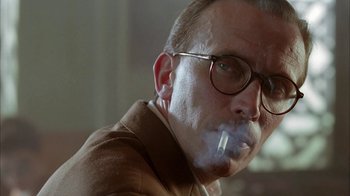 Movie still from “Naked Lunch” (1991), directed by David Cronenberg – A person smoking a cigarette; Close Up shot, Low angle