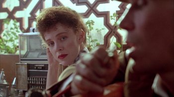 Movie still from “Naked Lunch” (1991), directed by David Cronenberg – A woman sitting in a car looking out the window; Close Up shot, Over the shoulder angle