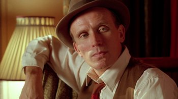 Movie still from “Naked Lunch” (1991), directed by David Cronenberg – A person wearing a hat; Close Up shot, Low angle