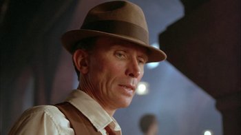 Movie still from “Naked Lunch” (1991), directed by David Cronenberg – A person wearing a hat; Close Up shot, Low angle