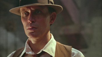 Movie still from “Naked Lunch” (1991), directed by David Cronenberg – A person wearing a hat; Close Up shot, Low angle