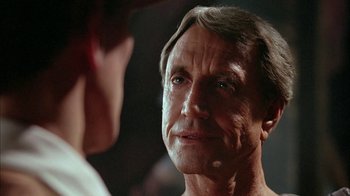 Movie still from “Naked Lunch” (1991), directed by David Cronenberg – An older man looking at a younger man; Close Up shot, Over the shoulder angle