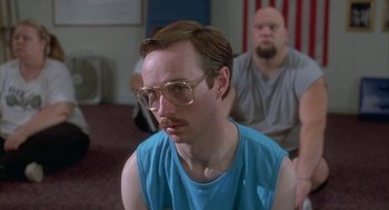 Movie still from “Napoleon Dynamite” (2004), directed by Jared Hess – A man with a beard and glasses sitting in front of another man with a beard; Close Up shot, Over the shoulder angle