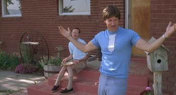 Movie still from “Napoleon Dynamite” (2004), directed by Jared Hess – Two men sitting on steps playing a game of frisbee; Medium shot, Low angle