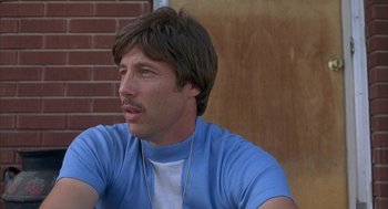 Movie still from “Napoleon Dynamite” (2004), directed by Jared Hess – A person wearing a blue shirt; Close Up shot, Low angle