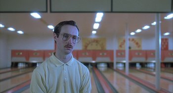 Movie still from “Napoleon Dynamite” (2004), directed by Jared Hess – A man with glasses standing in a bowling alley; Close Up shot, Low angle