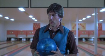 Movie still from “Napoleon Dynamite” (2004), directed by Jared Hess – A man holding a bowling ball in a bowling alley; Close Up shot, Low angle