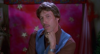 Movie still from “Napoleon Dynamite” (2004), directed by Jared Hess – A man in a brown shirt and a blue vest; Close Up shot, Low angle