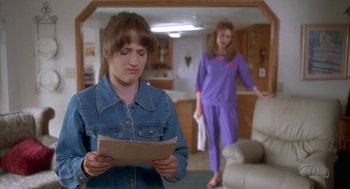 Movie still from “Napoleon Dynamite” (2004), directed by Jared Hess – Two women are standing in a living room and one of them is reading a piece of paper; Medium shot, Over the shoulder angle
