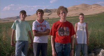 Movie still from “Napoleon Dynamite” (2004), directed by Jared Hess – A group of young men standing on top of a grass covered field; Medium shot, Low angle