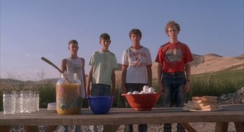 Movie still from “Napoleon Dynamite” (2004), directed by Jared Hess – A group of young men standing next to each other on top of a wooden table; Medium shot, Low angle