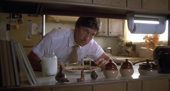 Movie still from “Napoleon Dynamite” (2004), directed by Jared Hess – A man in a white dress shirt and tie eating food; Close Up shot, Low angle
