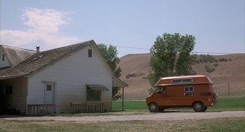 Movie still from “Napoleon Dynamite” (2004), directed by Jared Hess – An rv parked in front of a house on a dirt road; Extreme Wide shot, Low angle
