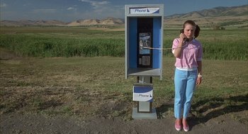 Movie still from “Napoleon Dynamite” (2004), directed by Jared Hess – A woman is talking on the phone by a payphone; Wide shot, Low angle