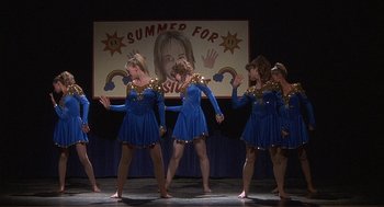Movie still from “Napoleon Dynamite” (2004), directed by Jared Hess – A group of young women performing a dance on a stage; Wide shot, Low angle