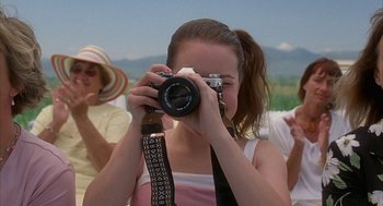 Movie still from “Napoleon Dynamite” (2004), directed by Jared Hess – A woman taking a picture with a camera; Close Up shot, Low angle
