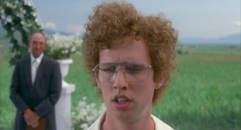 Movie still from “Napoleon Dynamite” (2004), directed by Jared Hess – A young man with curly brown hair wearing glasses; Close Up shot, Over the shoulder angle