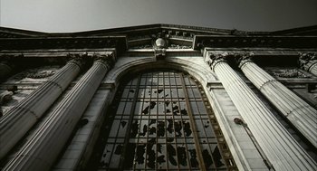 Movie still from “Naqoyqatsi” (2002), directed by Godfrey Reggio – An old building with a very large window; Extreme Wide shot, Low angle