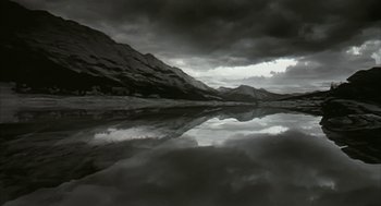 Movie still from “Naqoyqatsi” (2002), directed by Godfrey Reggio – A body of water that has mountains in the background; Extreme Wide shot, Low angle