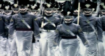Movie still from “Naqoyqatsi” (2002), directed by Godfrey Reggio – A group of men dressed in uniforms are standing in formation; Wide shot, Low angle