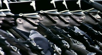 Movie still from “Naqoyqatsi” (2002), directed by Godfrey Reggio – A group of men in uniform are lined up; Extreme Close Up shot, Low angle