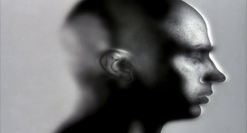 Movie still from “Naqoyqatsi” (2002), directed by Godfrey Reggio – A black - and - white photo of a person's ear; Extreme Close Up shot, Overhead angle