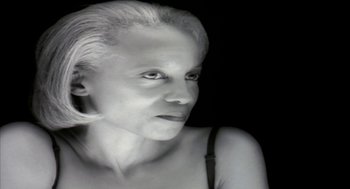 Movie still from “Naqoyqatsi” (2002), directed by Godfrey Reggio – A black and white photo of a woman's face; Close Up shot, Low angle