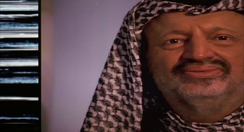 Movie still from “Naqoyqatsi” (2002), directed by Godfrey Reggio – A person wearing a headscarf; Close Up shot, Low angle