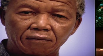 Movie still from “Naqoyqatsi” (2002), directed by Godfrey Reggio – An older man with a gray beard is looking at the camera; Extreme Close Up shot, Low angle