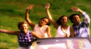 Movie still from “Naqoyqatsi” (2002), directed by Godfrey Reggio – A group of young people riding in a car; Medium shot, High angle