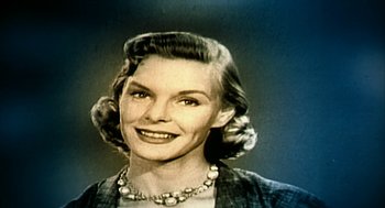 Movie still from “Naqoyqatsi” (2002), directed by Godfrey Reggio – An old photo of a woman smiling for the camera; Close Up shot, Low angle