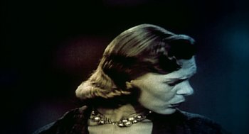 Movie still from “Naqoyqatsi” (2002), directed by Godfrey Reggio – A person wearing a necklace; Close Up shot, Low angle