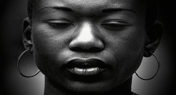 Movie still from “Naqoyqatsi” (2002), directed by Godfrey Reggio – A black and white photo of a woman's face; Extreme Close Up shot, Overhead angle