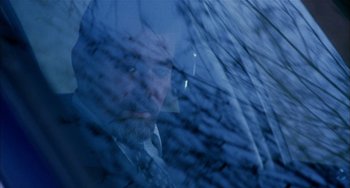 Movie still from “Narc” (2002), directed by Joe Carnahan – A man with a beard is looking out of a car window; Close Up shot, Low angle