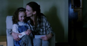 Movie still from “Narc” (2002), directed by Joe Carnahan – A woman sitting on a chair with a child; Medium shot, Over the shoulder angle