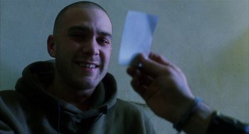 Movie still from “Narc” (2002), directed by Joe Carnahan – A man holding a piece of paper in front of him; Close Up shot, Over the shoulder angle